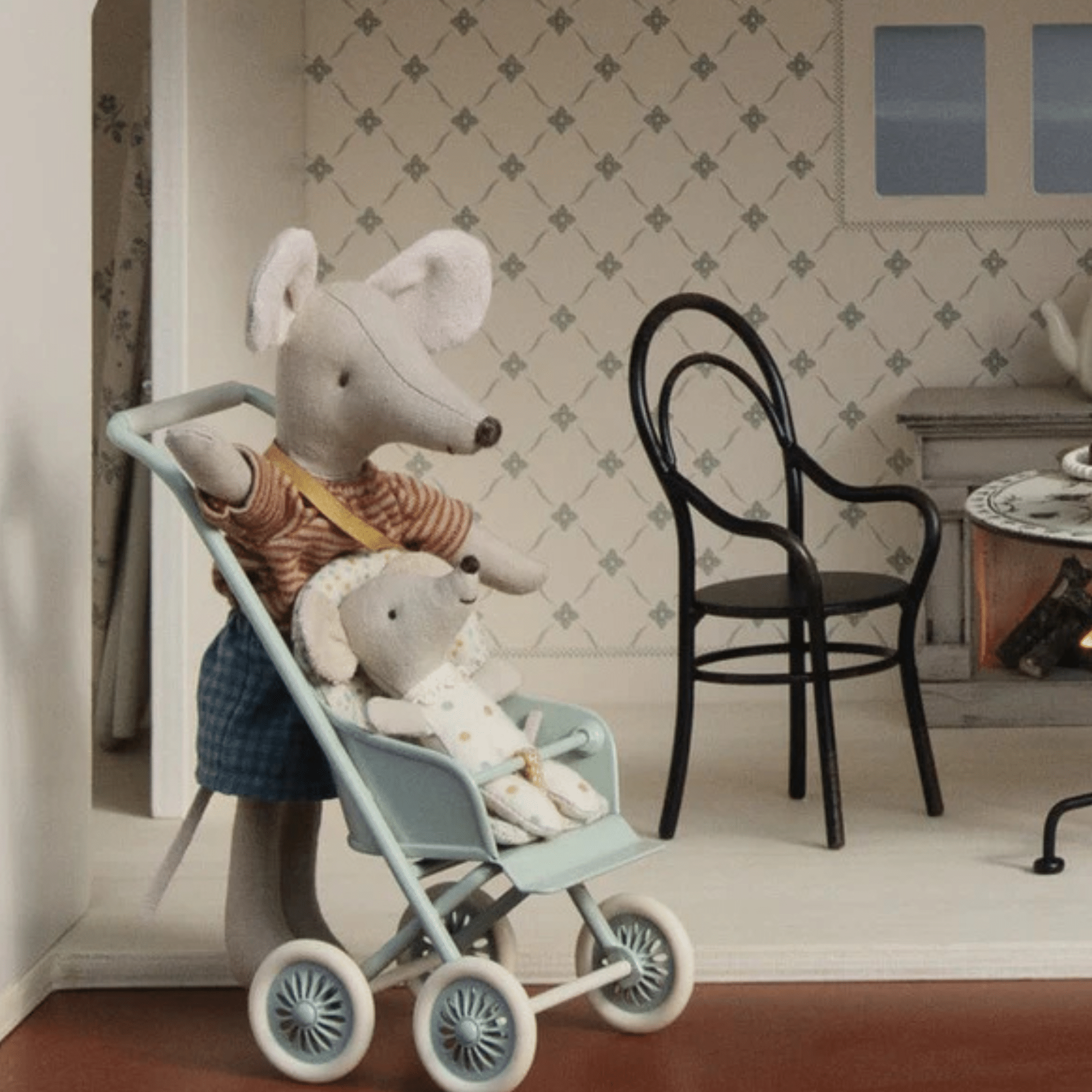 Vintageinspirerad miniatyrstol i metall med armstöd, perfekt för dockhus och miniatyrlekar.