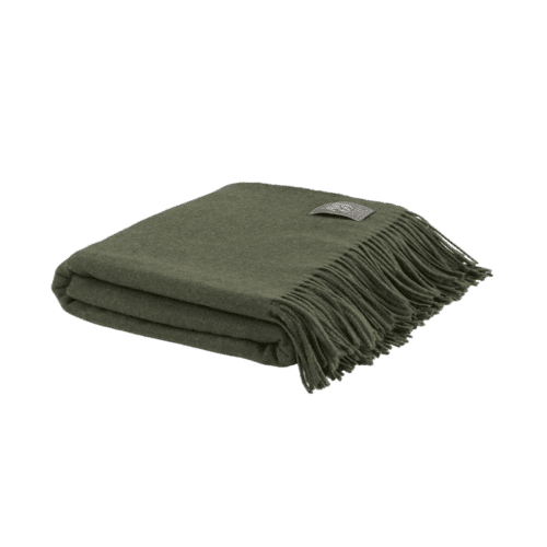 Grön pläd i ull och kashmir i färgen Army, dekorativt placerad i soffa för ett lugnt och ombonat hem